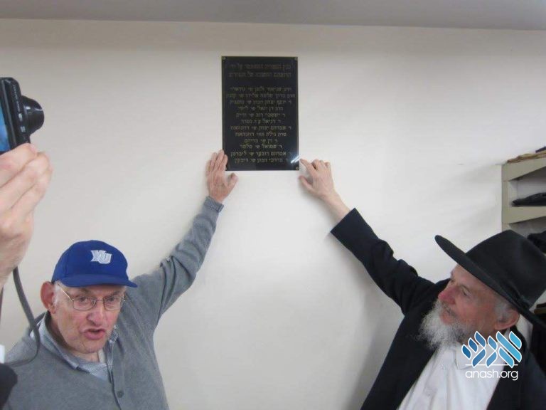 Rabbi Levin showing Rabbi Rakeffet the plaque that his friend and classmate Barry Liberman donated to the library